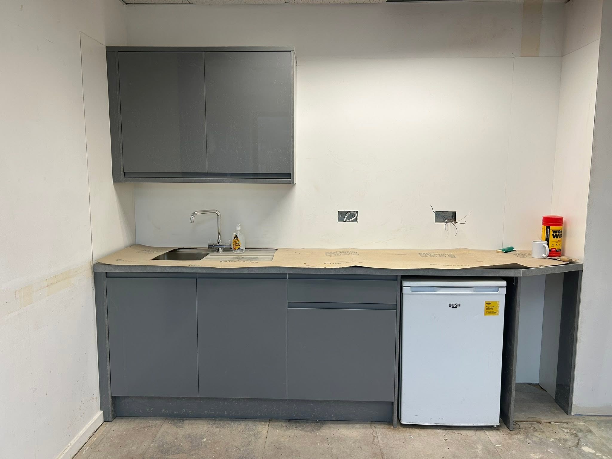 Grey kitchen units with sink and wall cabinet