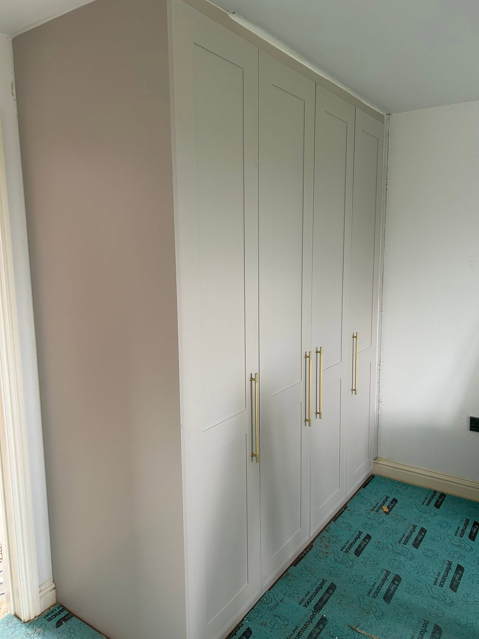 White shaker fitted wardrobes with brass handles