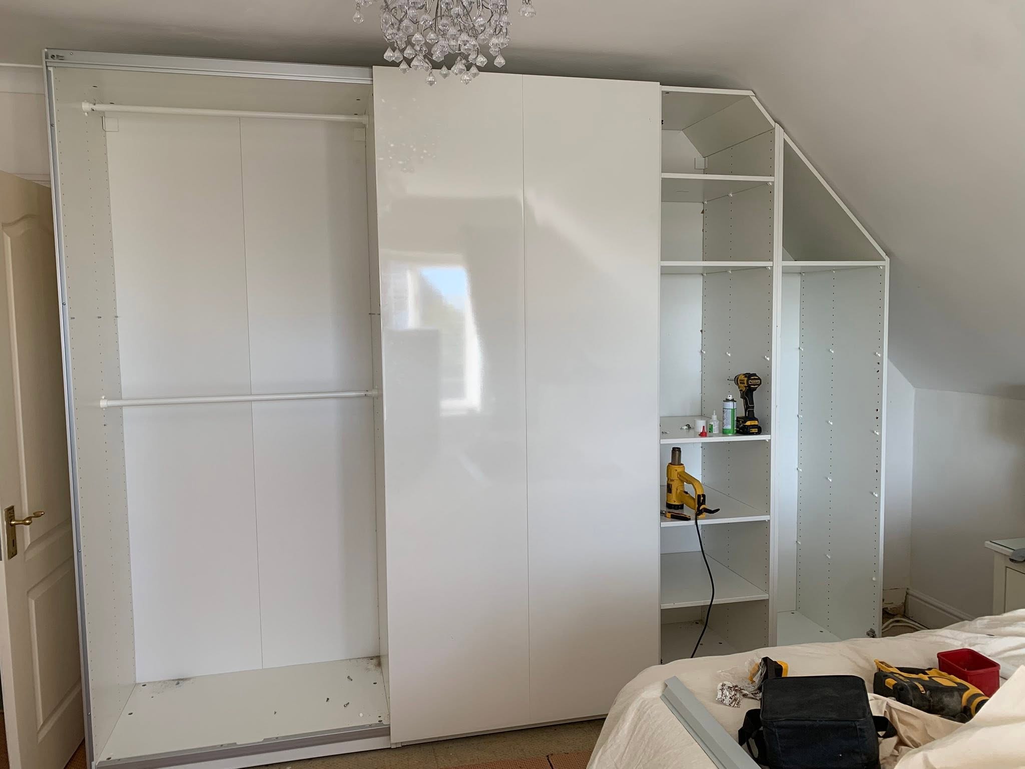 White sliding wardrobe with open hanging space and sloped shelving